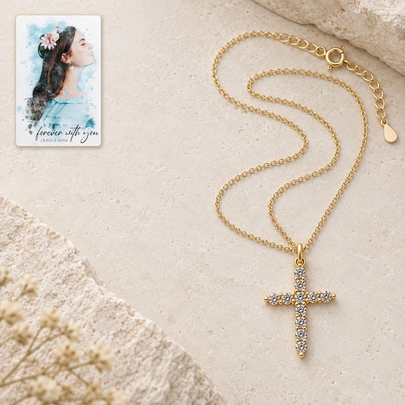Complete gold-tone necklace arranged on ivory stone style, with an upright eleven-stone style cross, fine chain, spring-ring clasp and extension links. A personalized digital greeting card is shown alongside.