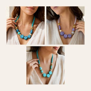 May include: A beaded necklace featuring a mix of round turquoise beads, larger faceted turquoise-colored stones, and small gold-toned spacers. The design includes a central arrangement of geometric shapes and smooth spheres in varying shades of blue.