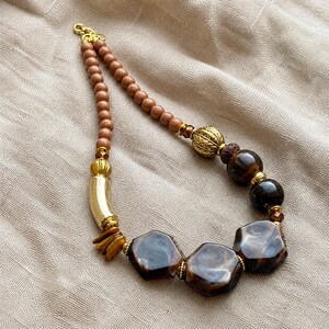 Brown and Beige Statement Beaded Necklace presented in an open jewelry gift box on natural linen