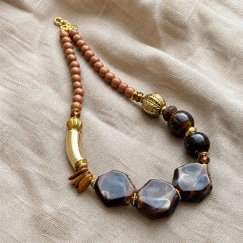 Brown and Beige Statement Beaded Necklace presented in an open jewelry gift box on natural linen