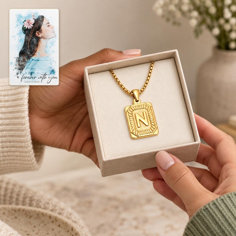 Adult gift-giving moment showing the gold tone N initial necklace inside an open styling box. A personalized digital greeting card is shown alongside.