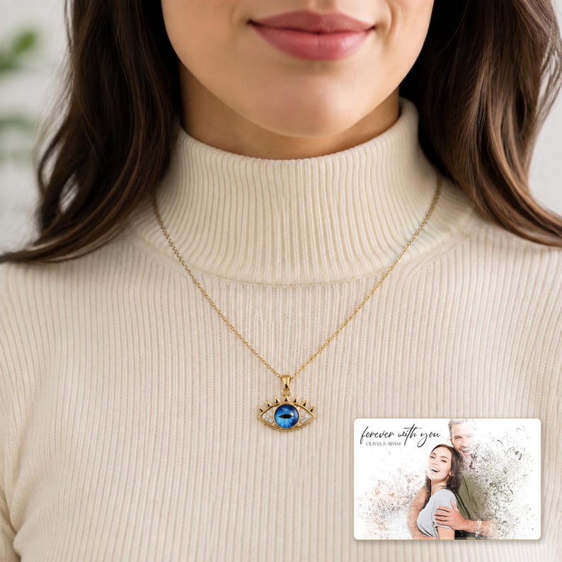 Gold-tone necklace with a blue eye-shaped pendant, worn view. A personalized greeting-card example appears in the corner.