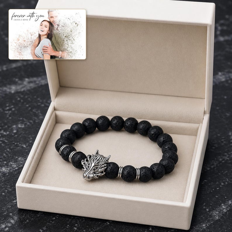 Black bead bracelet with silver-tone wolf-head detail, presentation in an open jewelry box. A personalized greeting-card example appears in the corner.