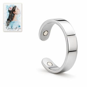 Silver-tone open C-shaped ring photographed on white with both rounded ends and inner circular details visible. A personalized digital greeting card is shown alongside.