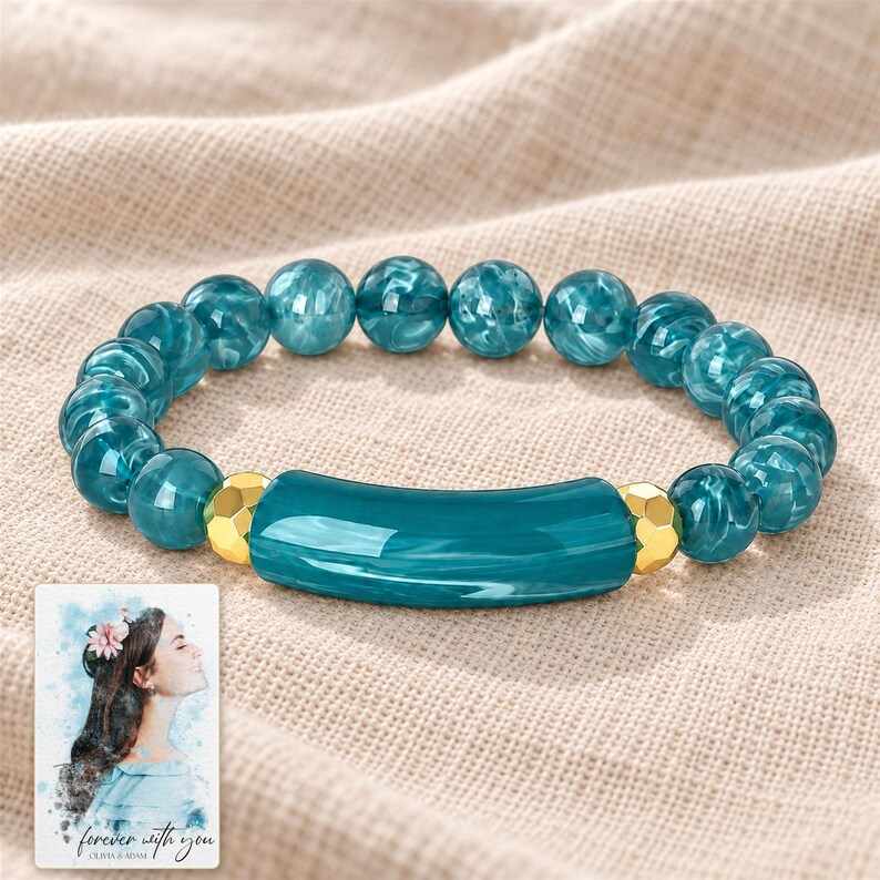 Peacock Tide Bar Bracelet arranged on soft ivory linen in a refined neutral flat lay. A personalized digital greeting card is shown alongside.