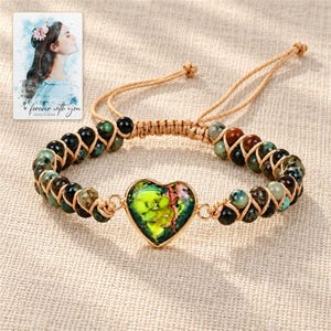 Verdant Heart Woven Bracelet arranged on soft ivory linen in a refined neutral flat lay. A personalized digital greeting card is shown alongside.