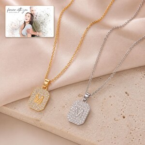 Mosaic Initial M Necklace Duo photographed in warm natural window light in an elegant home setting.
