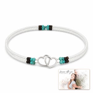Tidal Hearts Beaded Anklet shown during a believable gift-giving moment between adults with the exact jewelry visible.