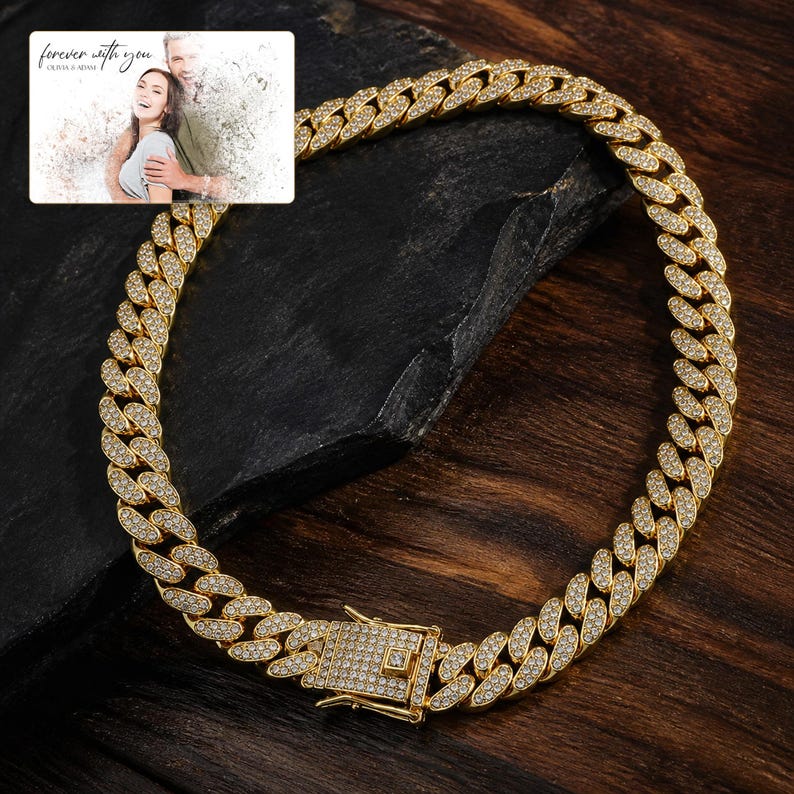 May include: A gold-toned cuban link chain necklace featuring a box clasp, with every link and the clasp surface fully encrusted with small clear stones. An inset rectangular card displays a photo of a couple with the text forever with you.