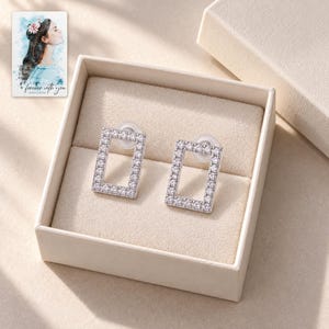 Rectangle Moissanite Stud Earrings, displayed in a presentation box. A sample personalized digital greeting card is shown alongside.