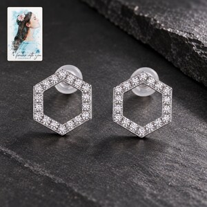 Hexagon Moissanite Stud Earrings, shown against a dark background. A sample personalized digital greeting card is shown alongside.