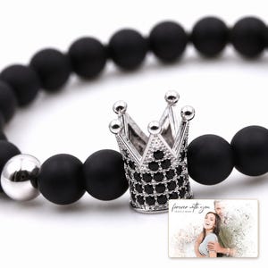 Midnight Crown Bead Bracelet shown during a warm gift-receiving moment between adults with the exact jewelry visible.