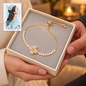Golden Petal Slider Bracelet shown during a warm gift-receiving moment between adults with the jewelry visible. A personalized digital greeting card is shown alongside.