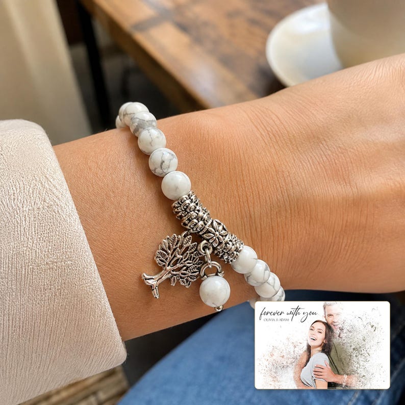 White and gray bead bracelet with silver-tone tree and hanging bead details, adult lifestyle view. A personalized greeting-card example appears in the corner.