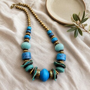 Rose Gold and Brown Statement Beaded Necklace presented in an open jewelry gift box on natural linen