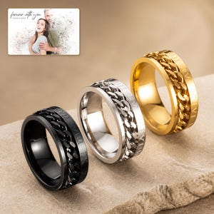 CipherSpin Roman Chain Ring photographed in warm natural window light in an elegant home setting.