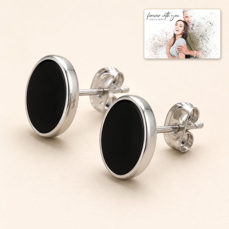 Black oval stud earrings with silver-tone edges, display view. A personalized greeting-card example appears in the corner.