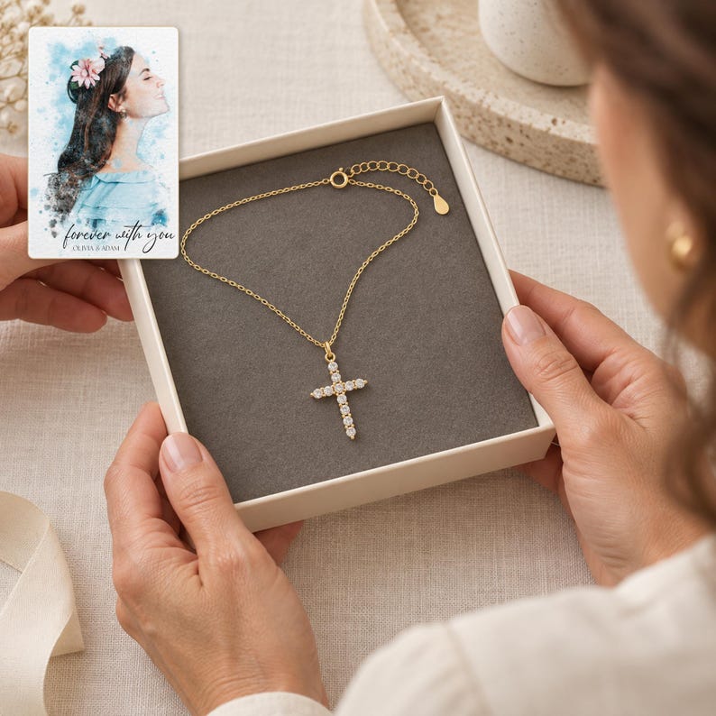 Adult recipient views the Golden cross necklace in an open box above an ivory linen table. A personalized digital greeting card is shown alongside.