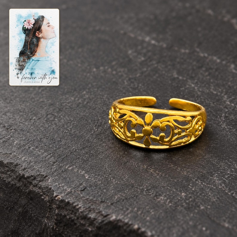 Golden Bloom Filigree Ring styled against a dark luxury surface with the exact product finish clearly visible. A personalized digital greeting card is shown alongside.