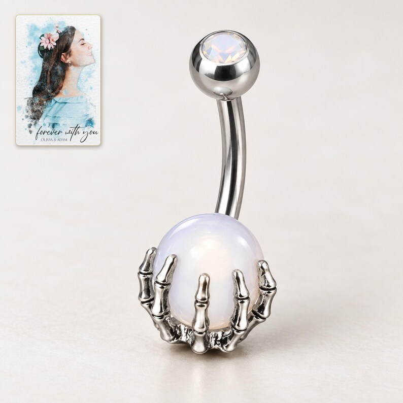White-ball skeleton-claw barbell on an ivory background, with its small faceted top stone style visible. A personalized digital greeting card is shown alongside.