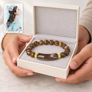 Cocoa Swirl Bar Bracelet shown during a believable gift-giving moment between adults with the jewelry visible. A personalized digital greeting card is shown alongside.