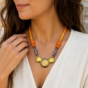 Orange and Beige Statement Beaded Necklace, Boho Handmade Jewelry, Artisan Gift for Her displayed on a jewelry bust with the layered beadwork and pendants visible