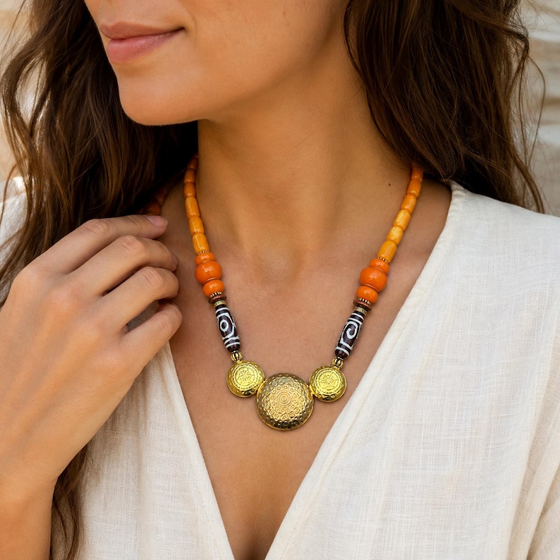 Orange and Beige Statement Beaded Necklace, Boho Handmade Jewelry, Artisan Gift for Her displayed on a jewelry bust with the layered beadwork and pendants visible