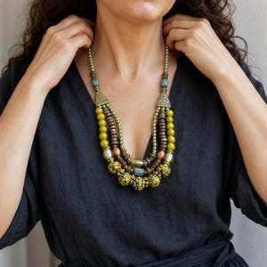 Three-piece handmade necklace set featuring brown and bronze beaded necklace, brown and yellow beaded necklace and gray and bronze beaded necklace, displayed together to show the coordinated colors and beadwork