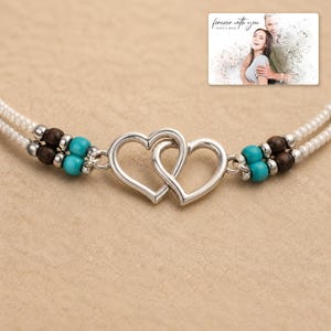 Tidal Hearts Beaded Anklet shown during a warm gift-receiving moment between adults with the exact jewelry visible.