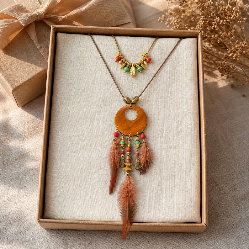 May include: A two-piece necklace set featuring a short beaded chain with small green, red, and gold-toned leaf charms, and a longer cord necklace with a large wooden circle pendant, colorful beads, and three brown feathers hanging from the base.