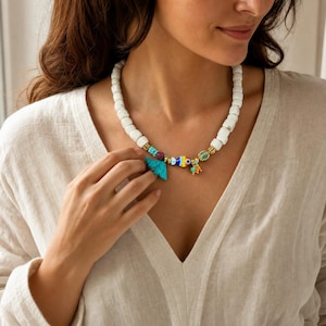 beaded evil-eye necklace displayed on a jewelry bust with the layered beadwork and pendants visible