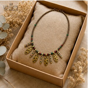 Antique Gold Leaf Charm Necklace presented in an open jewelry gift box on natural linen