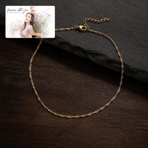 Puede incluir: Un collar de cadena trenzada en tono dorado con cierre de mosquet&oacute;n y cadena extensora ajustable. Se incluye una tarjeta rectangular que muestra una fotograf&iacute;a de una pareja con el texto "forever with you" y "OLIVIA & ADAM" impreso.