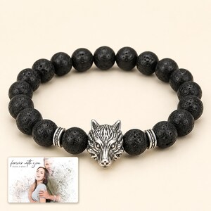 Black bead bracelet with silver-tone wolf-head detail, display view. A personalized greeting-card example appears in the corner.