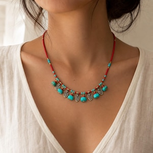 Turquoise Red Beaded Charm Necklace displayed on a jewelry bust, showing the necklace shape and artisan bead details