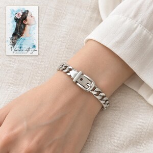 Adult woman's wrist wearing the polished silver tone belt buckle bracelet with a cream blouse cuff. A personalized digital greeting card is shown alongside.