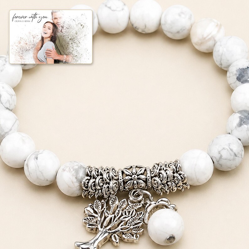 White and gray bead bracelet with silver-tone tree and hanging bead details, close detail view. A personalized greeting-card example appears in the corner.
