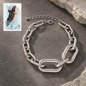 silver tone Arc Statement Choker styled against a dark luxury surface with the exact product finish clearly visible. A personalized digital greeting card is shown alongside.