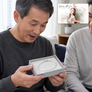 Silken Line 925 Snake Bracelet shown during a warm gift-receiving moment between adults with the exact jewelry visible.