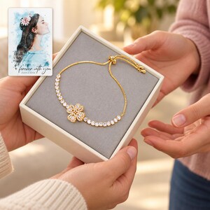Golden Petal Slider Bracelet shown during a believable gift-giving moment between adults with the jewelry visible. A personalized digital greeting card is shown alongside.