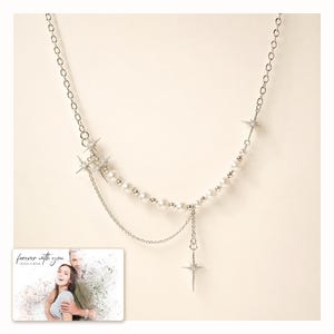 Silver-tone layered necklace with pale beads and pointed star charms, catalog view. A personalized greeting-card example appears in the corner.