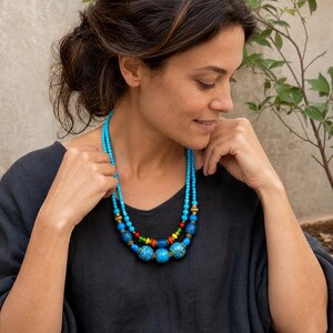 Three-piece handmade necklace set featuring blue and clear beaded necklace, rose gold and gray beaded necklace and brown and silver beaded necklace, displayed together to show the coordinated colors and beadwork