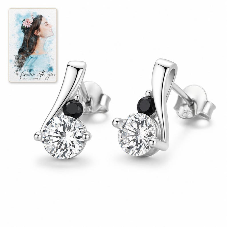 Adult man giving the black and clear zircon stud earrings in an open jewelry box to an adult woman.