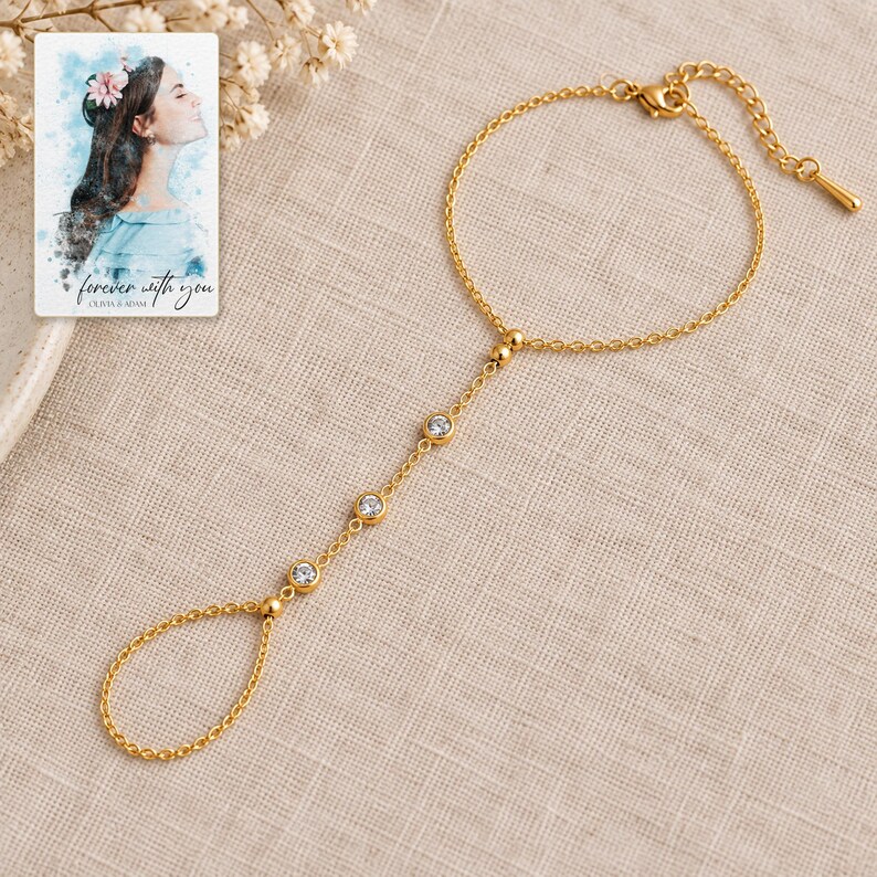 Golden Three stone style Hand Chain arranged on soft ivory linen in a refined neutral flat lay. A personalized digital greeting card is shown alongside.