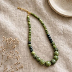 Gray and Brown Statement Beaded Necklace presented in an open jewelry gift box on natural linen