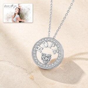White Gold color HOPE necklace with a clear CZ halo and heart-cut center stone in a bright jewelry hero scene.