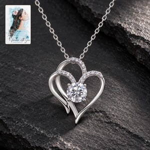 Double Heart Pendant Necklace, shown against a dark background. A sample personalized digital greeting card is shown alongside.