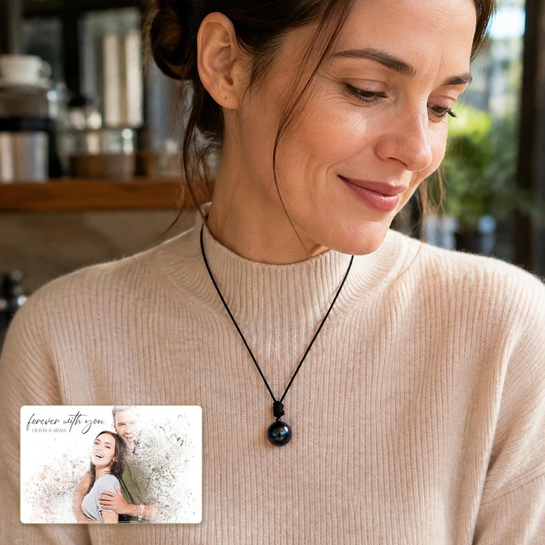 Black cord necklace with a dark round pendant, adult lifestyle view. A personalized greeting-card example appears in the corner.