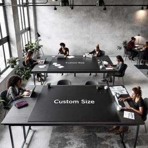 Puede incluir: Un espacio de oficina moderno con varias mesas grandes de madera oscura con superficies negras. Las mesas tienen el texto "Custom Size". Varias personas están sentadas en las mesas, trabajando en computadoras portátiles. La habitación tiene ventanas grandes.