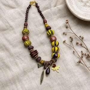 Brown and Yellow Statement Beaded Necklace presented in an open jewelry gift box on natural linen
